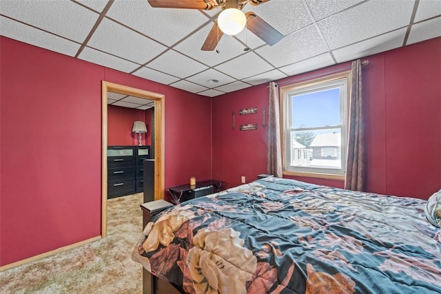 carpeted bedroom featuring a drop ceiling and ceiling fan