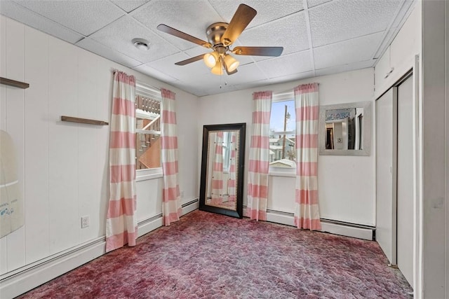 spare room with ceiling fan, a drop ceiling, carpet, and plenty of natural light