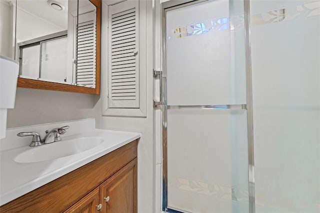 bathroom with vanity and a shower with shower door