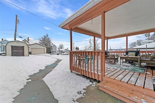 snow covered deck with a shed