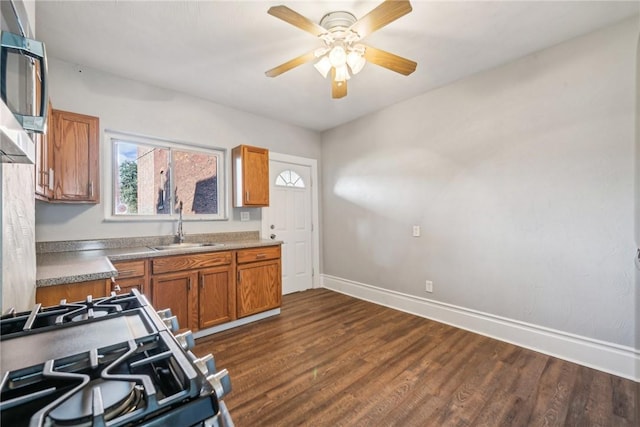 kitchen featuring dark hardwood / wood-style floors, ceiling fan, sink, and appliances with stainless steel finishes