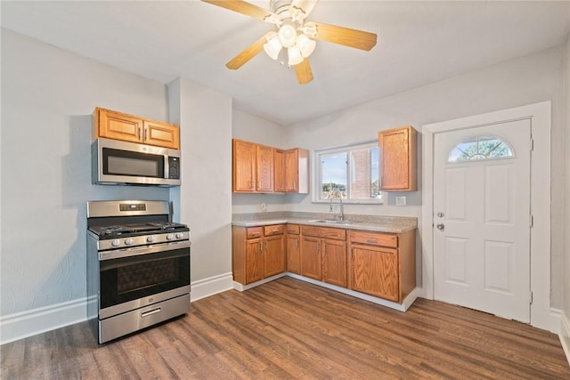 kitchen with ceiling fan, sink, stainless steel appliances, and dark hardwood / wood-style floors