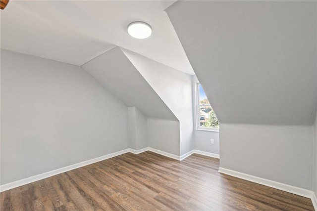 additional living space with dark hardwood / wood-style floors and lofted ceiling