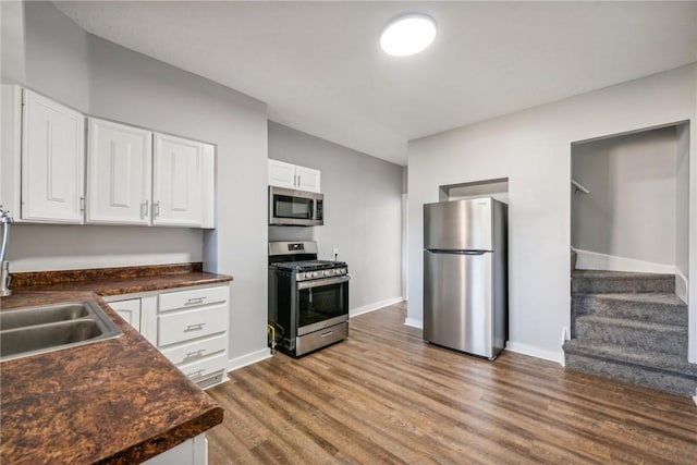 kitchen with white cabinetry, sink, dark hardwood / wood-style floors, and appliances with stainless steel finishes