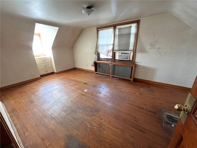 additional living space featuring wood-type flooring, lofted ceiling, and cooling unit