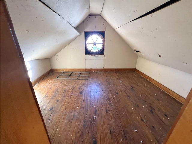 bonus room with hardwood / wood-style floors and vaulted ceiling