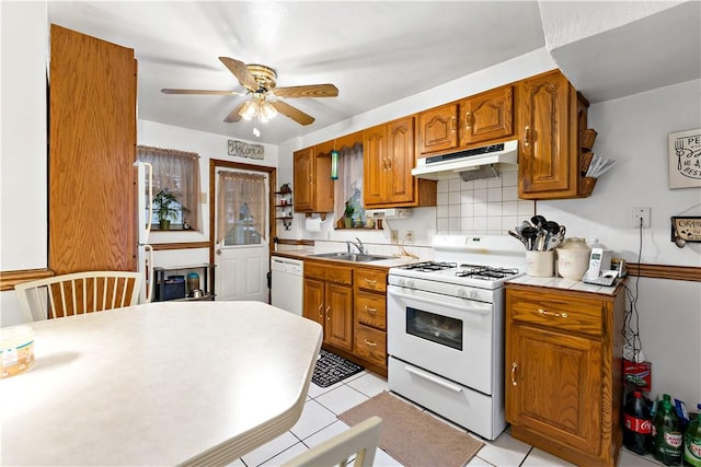 kitchen with ceiling fan, tasteful backsplash, sink, white appliances, and light tile patterned floors