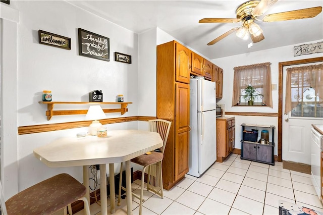 kitchen featuring ceiling fan, white appliances, and light tile patterned flooring