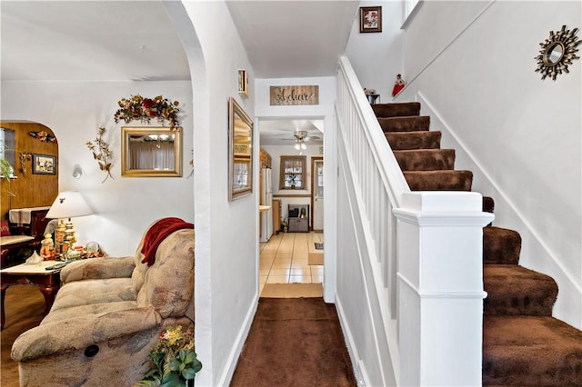 stairs featuring ceiling fan and tile patterned floors