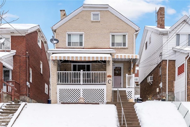 view of front facade with a wall mounted air conditioner and a porch