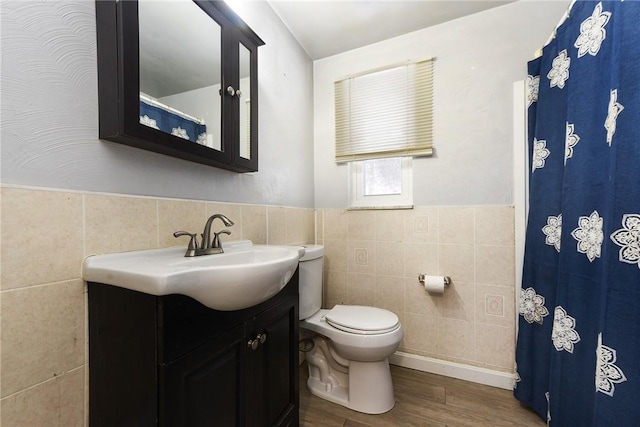 bathroom featuring hardwood / wood-style floors, vanity, toilet, and tile walls