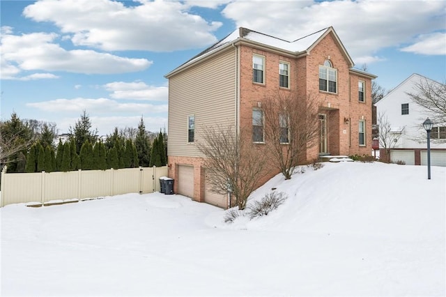 snow covered property featuring a garage