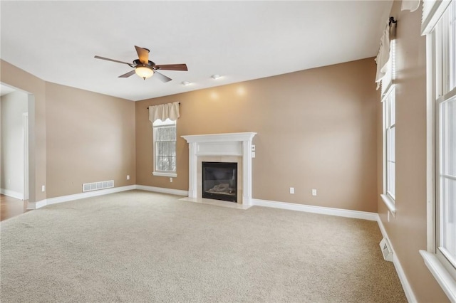 unfurnished living room featuring ceiling fan and light carpet