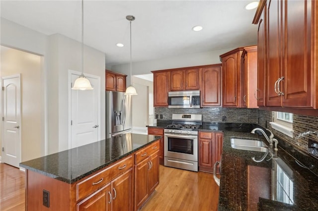 kitchen with pendant lighting, sink, tasteful backsplash, and appliances with stainless steel finishes