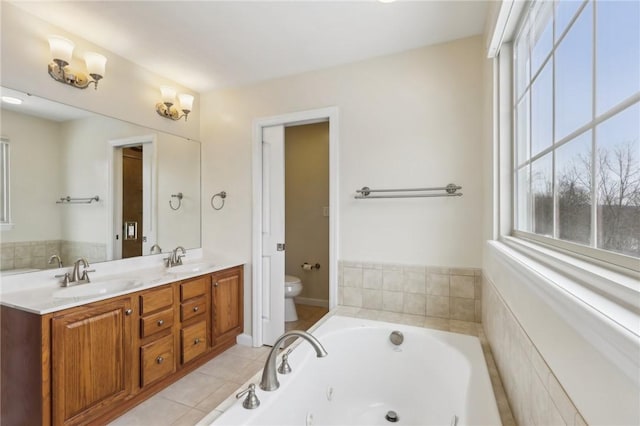 bathroom featuring vanity, tiled bath, tile patterned floors, and toilet