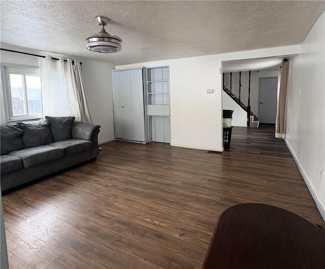 living room featuring dark wood-type flooring and a textured ceiling