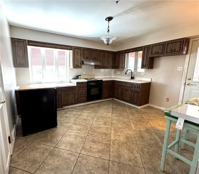 kitchen featuring black range with electric stovetop, plenty of natural light, sink, and pendant lighting