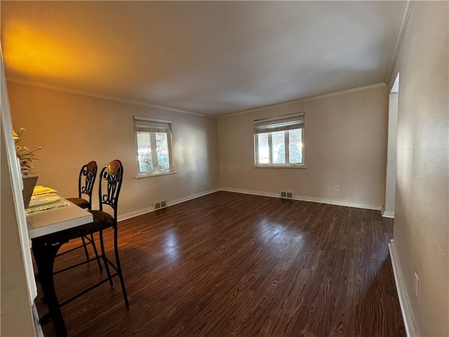 unfurnished dining area featuring crown molding, plenty of natural light, and dark hardwood / wood-style floors