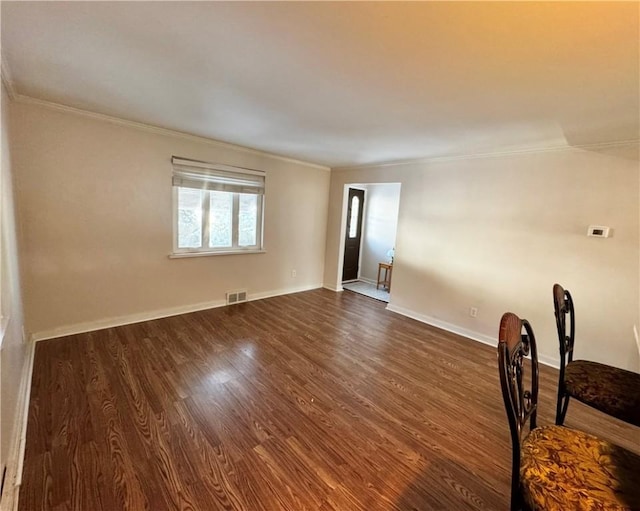 spare room with dark wood-type flooring and ornamental molding