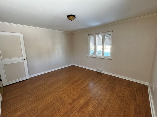 unfurnished room featuring ornamental molding and dark hardwood / wood-style floors