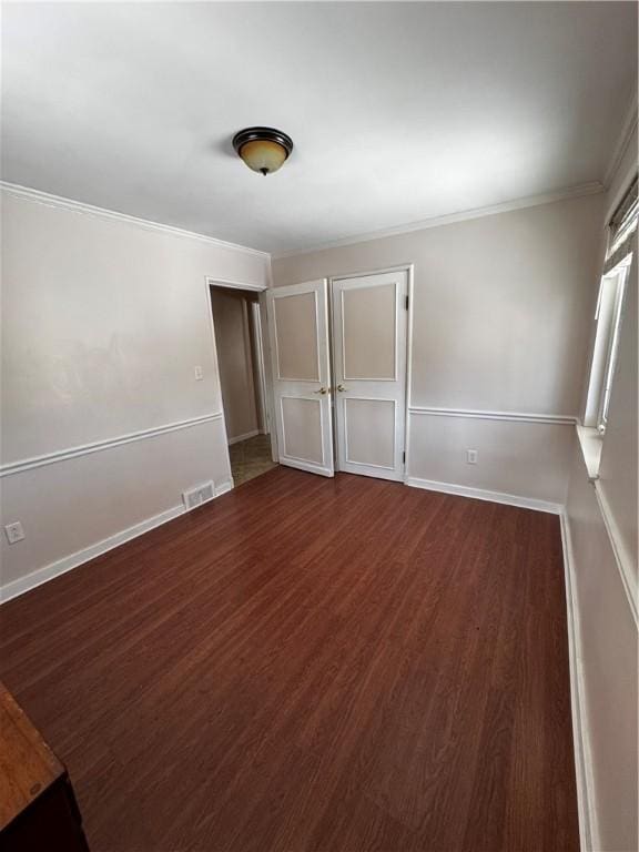 unfurnished bedroom with crown molding, dark hardwood / wood-style flooring, and a closet