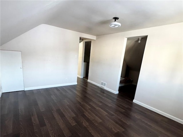 unfurnished room with lofted ceiling and dark hardwood / wood-style floors