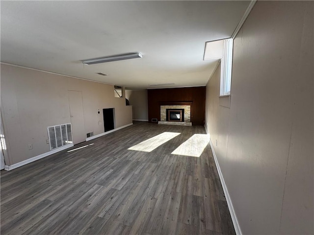 unfurnished living room featuring a fireplace, ornamental molding, and wood-type flooring