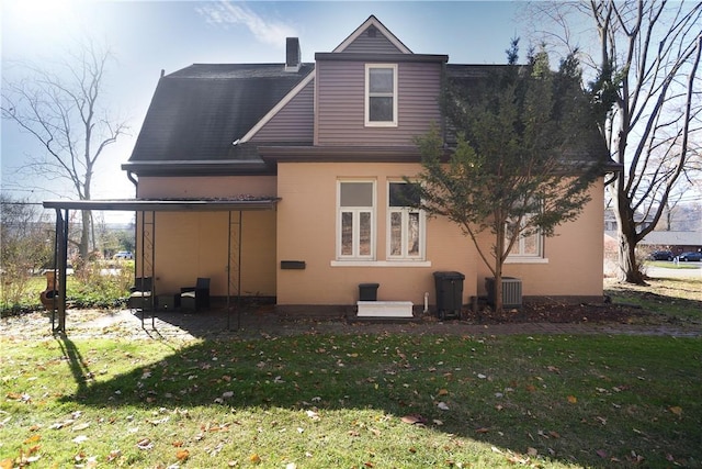 back of house with a yard and central air condition unit