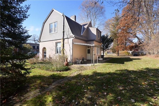 view of side of home with a yard and a patio