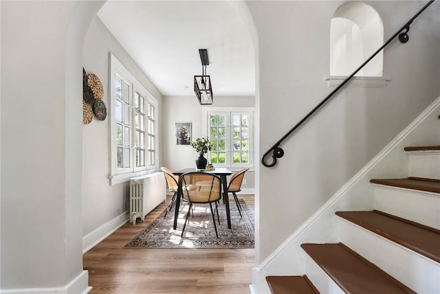 interior space with hardwood / wood-style flooring, radiator heating unit, and an inviting chandelier