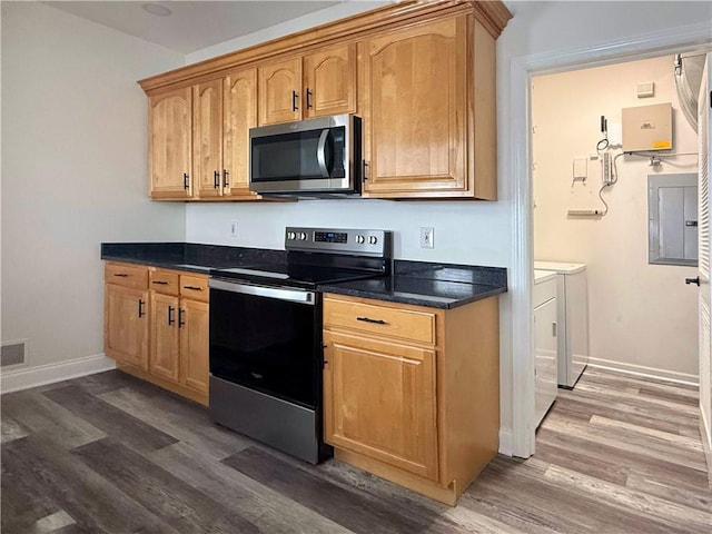 kitchen featuring appliances with stainless steel finishes, electric panel, and dark wood-type flooring