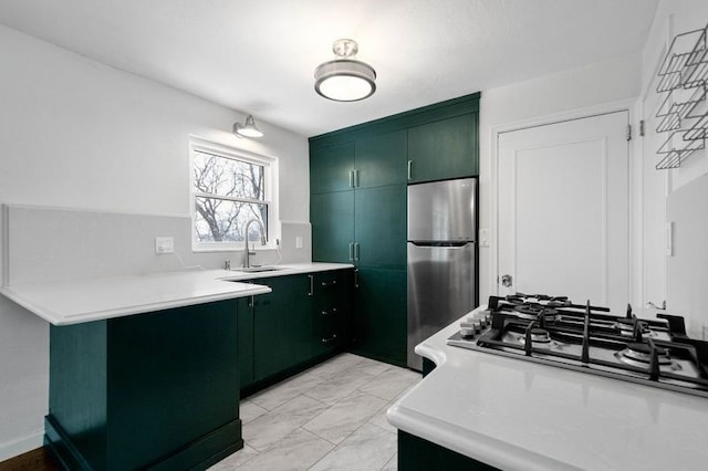 kitchen with green cabinets, sink, kitchen peninsula, and stainless steel appliances