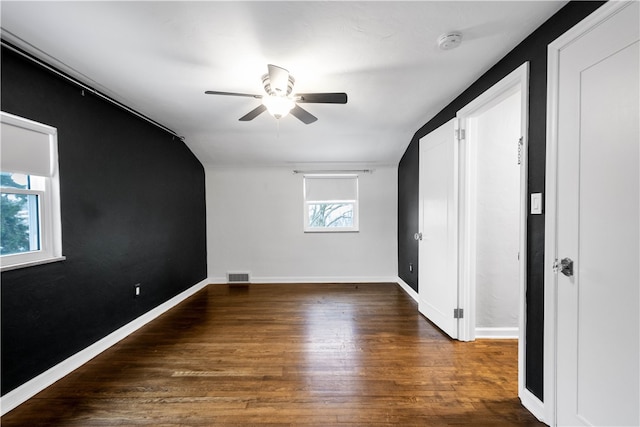 empty room featuring dark hardwood / wood-style flooring, plenty of natural light, lofted ceiling, and ceiling fan