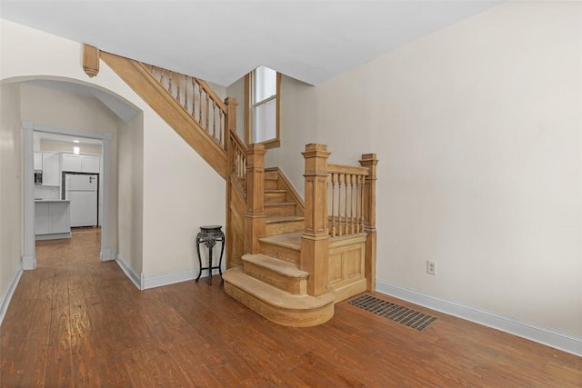 staircase with hardwood / wood-style floors