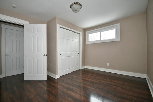 unfurnished bedroom with a closet and dark wood-type flooring