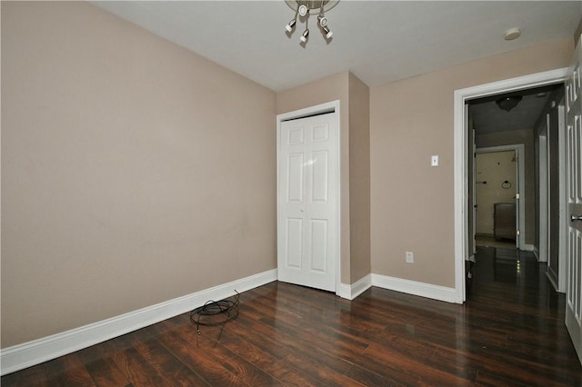 unfurnished bedroom with dark hardwood / wood-style flooring