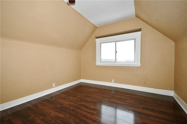 bonus room with dark hardwood / wood-style floors and vaulted ceiling