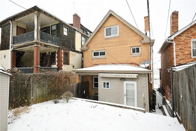 snow covered property featuring a balcony