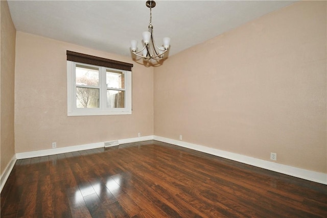 unfurnished room with dark hardwood / wood-style floors and a chandelier