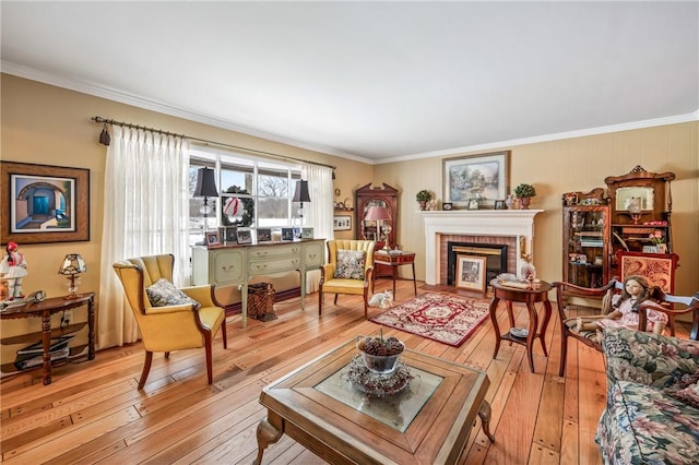 living room with light wood-type flooring, a fireplace, and ornamental molding