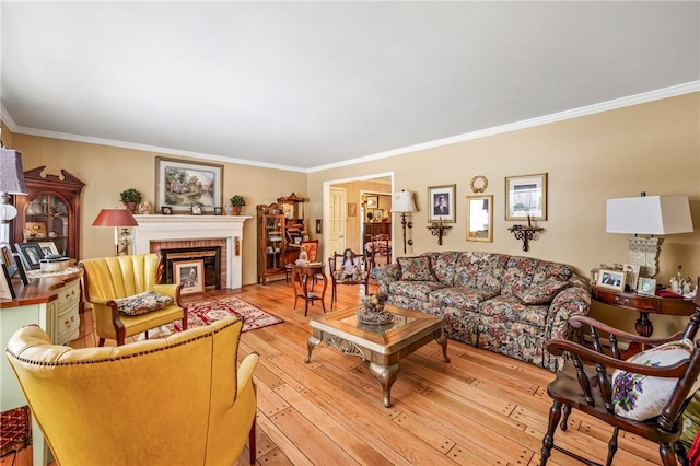 living room with crown molding, a fireplace, and light hardwood / wood-style flooring