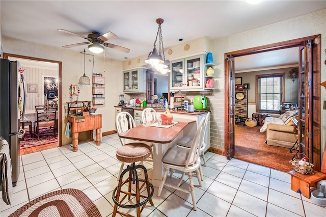 tiled dining space featuring ceiling fan