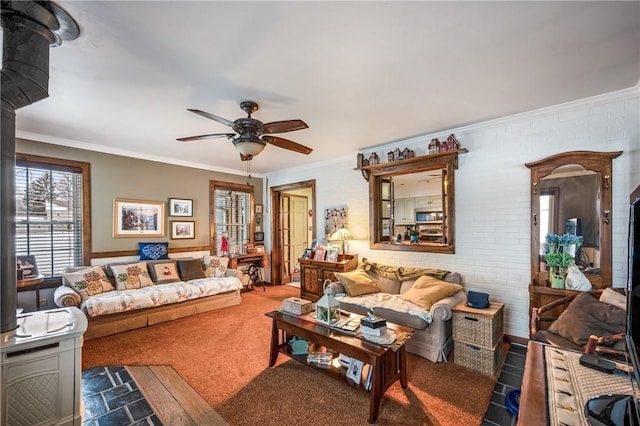 living room with ceiling fan, ornamental molding, brick wall, and a wood stove