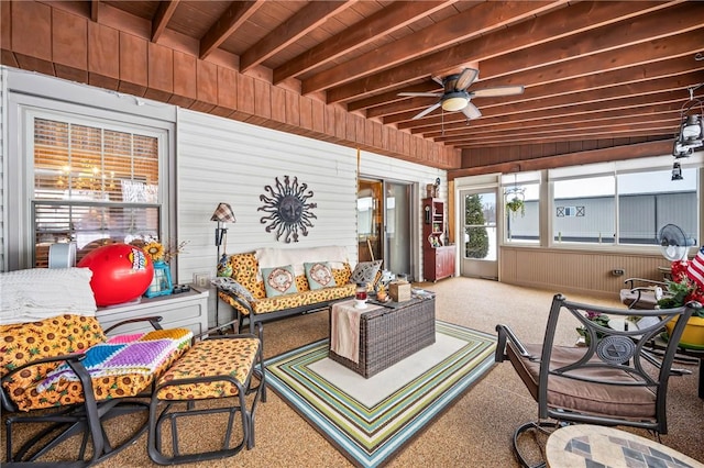 sunroom with beamed ceiling, ceiling fan, and wooden ceiling