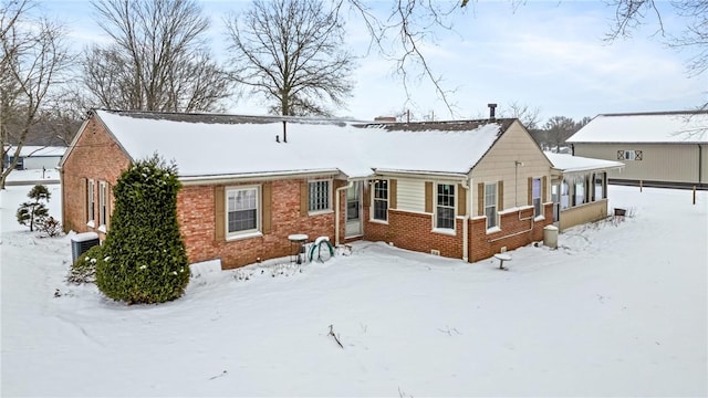 snow covered rear of property with central air condition unit