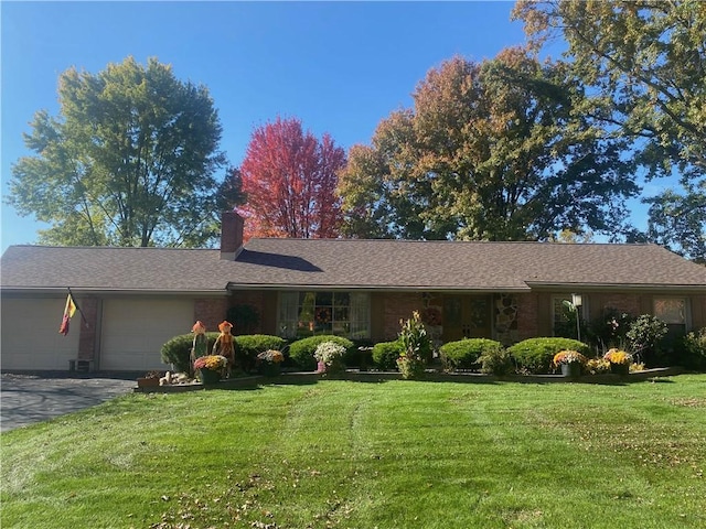 ranch-style home with a garage and a front lawn