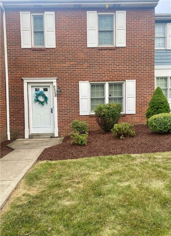 townhome / multi-family property with a front lawn