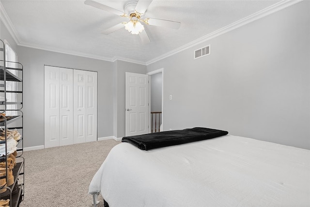 bedroom with carpet flooring, ceiling fan, a closet, and crown molding