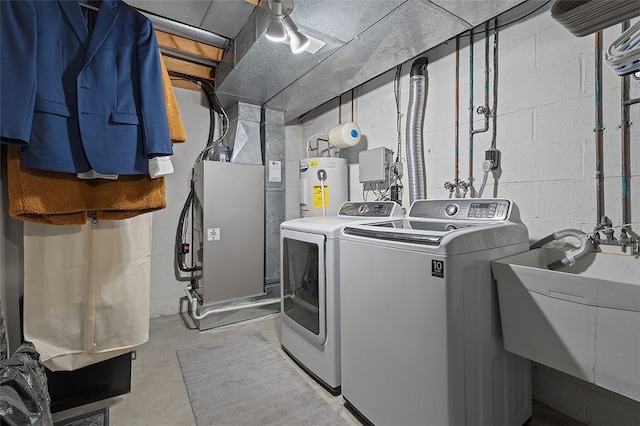 washroom featuring washer and dryer, electric water heater, and sink