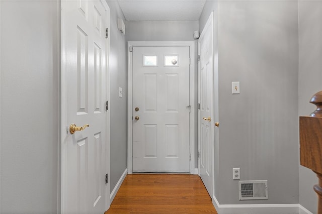 doorway featuring light hardwood / wood-style floors and a textured ceiling